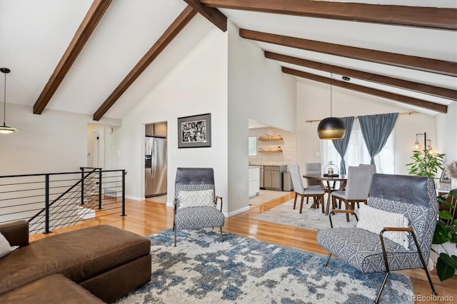living room featuring high vaulted ceiling, baseboards, beamed ceiling, and wood finished floors