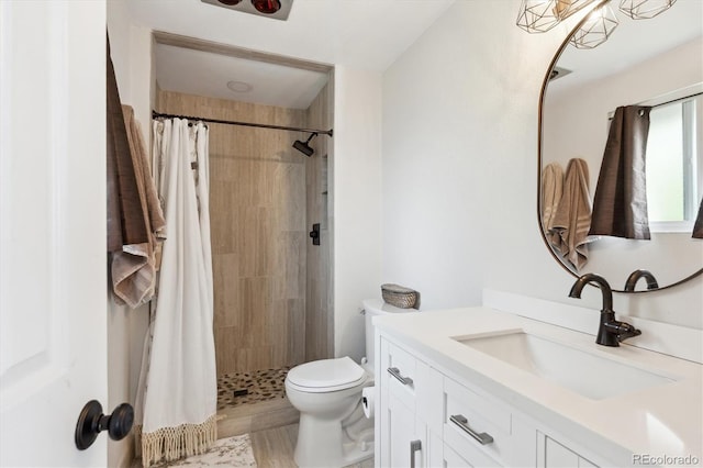 bathroom featuring vanity, toilet, and tiled shower