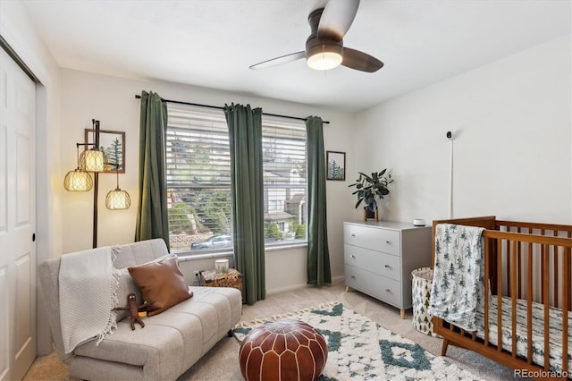 bedroom with a closet, a ceiling fan, baseboards, and light carpet