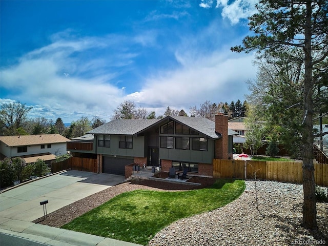 bi-level home with brick siding, a garage, fence, and driveway