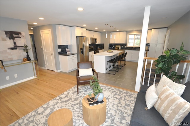 living room with sink and light hardwood / wood-style floors