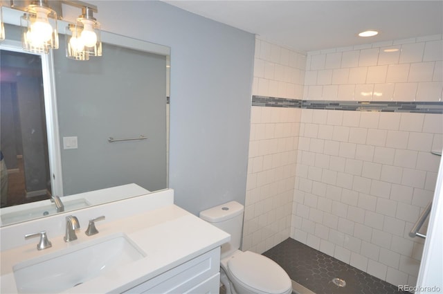 bathroom featuring tiled shower, vanity, and toilet