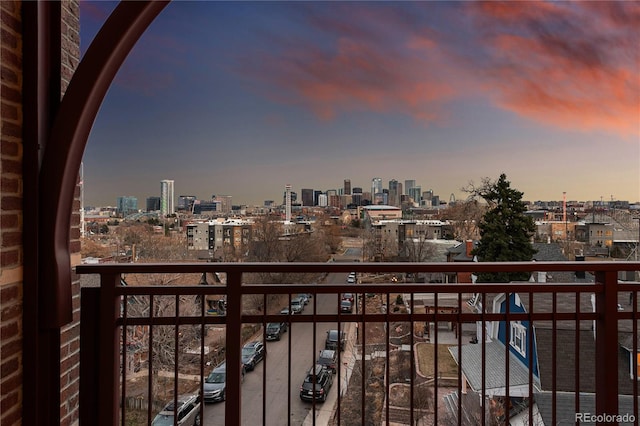 balcony at dusk featuring a city view