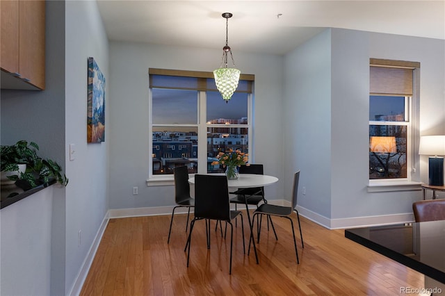 dining space with baseboards and wood finished floors