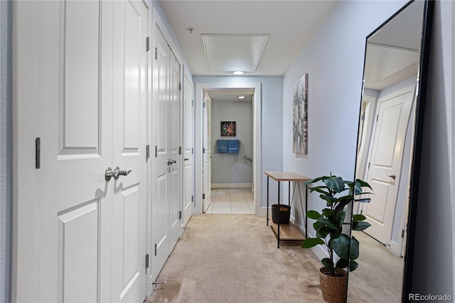 hall with light tile patterned floors, light colored carpet, and baseboards