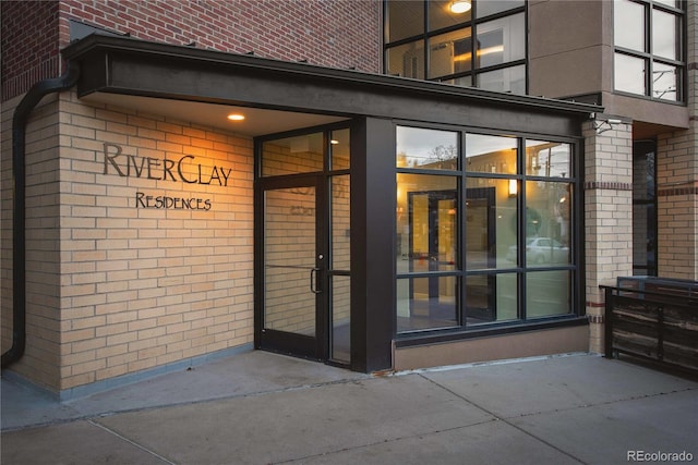 view of exterior entry featuring brick siding