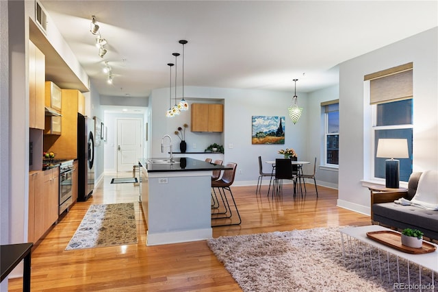 kitchen with a kitchen bar, visible vents, appliances with stainless steel finishes, a sink, and dark countertops