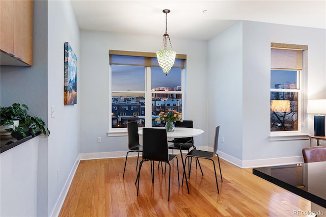 dining room featuring light wood finished floors and baseboards
