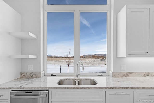 kitchen featuring stainless steel dishwasher, a wealth of natural light, sink, and white cabinetry