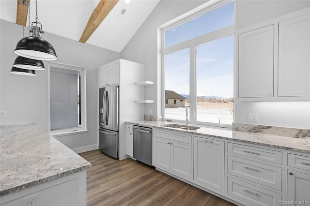 kitchen with white cabinetry, stainless steel appliances, hanging light fixtures, beam ceiling, and light stone counters