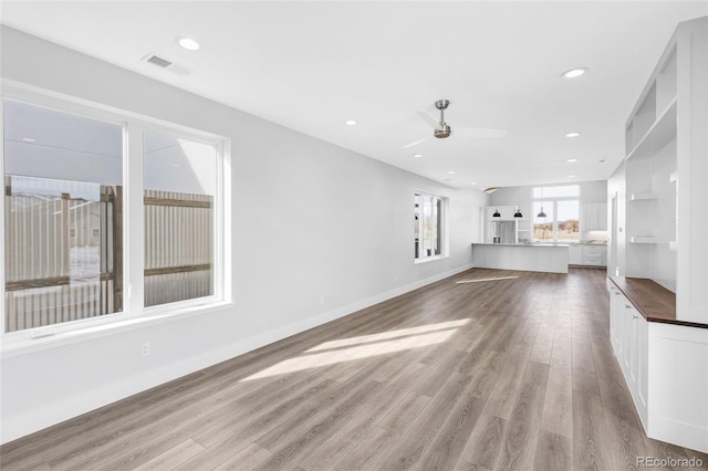 unfurnished living room with ceiling fan and light hardwood / wood-style flooring