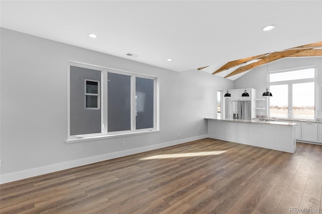 unfurnished living room featuring dark wood-type flooring and lofted ceiling with skylight