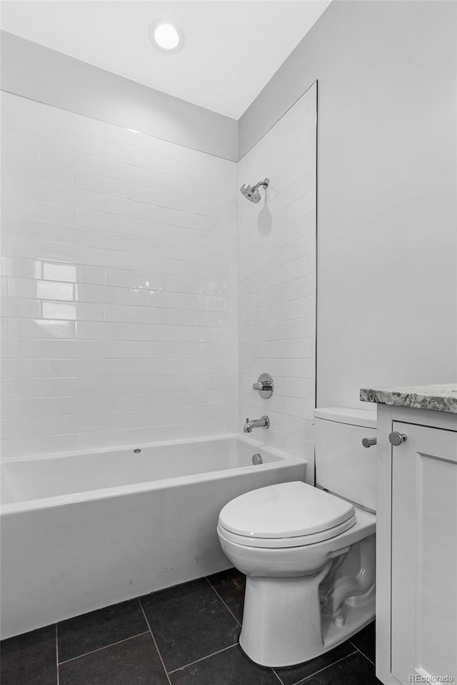 full bathroom with tiled shower / bath, tile patterned floors, vanity, and toilet