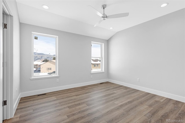 unfurnished room with ceiling fan, light wood-type flooring, and vaulted ceiling