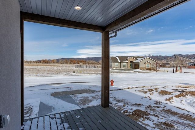 snow covered deck with a mountain view