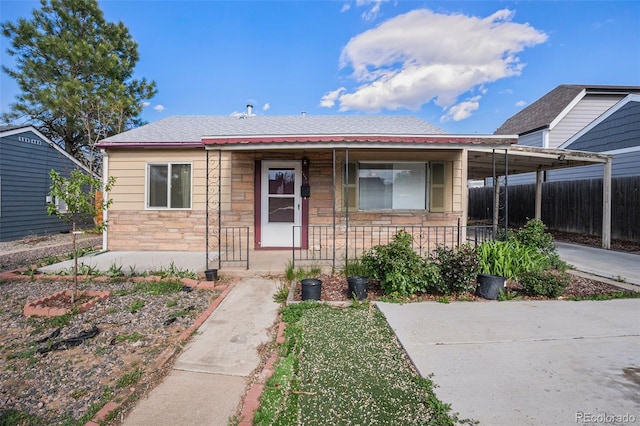 1910 S King St, Denver, CO 80219 - view of front of house with stone siding, a porch, and a carport