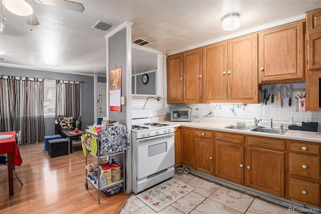 1910 S King St, Denver, CO 80219 - kitchen featuring white range with gas cooktop, a sink, light countertops, and tasteful backsplash