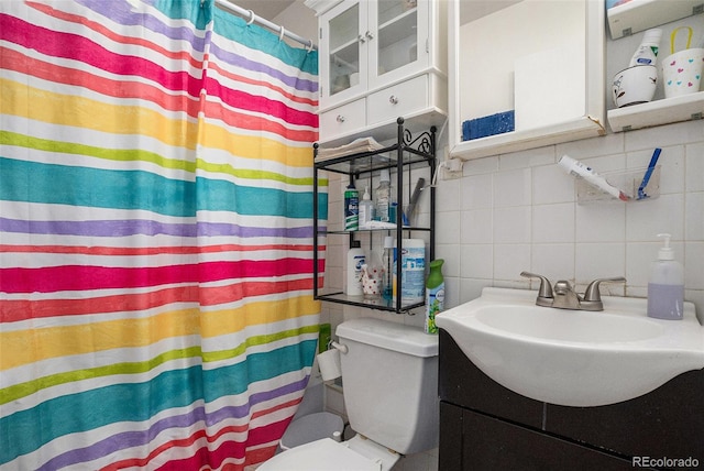 1910 S King St, Denver, CO 80219 - full bathroom featuring tile walls, toilet, tasteful backsplash, vanity, and curtained shower