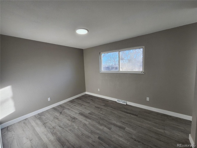 unfurnished room featuring dark hardwood / wood-style flooring