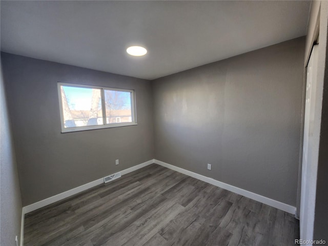 spare room featuring dark wood-type flooring