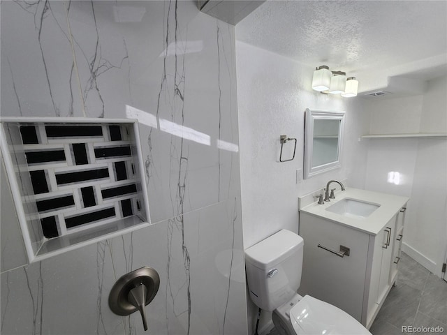 bathroom featuring a textured ceiling, toilet, and vanity