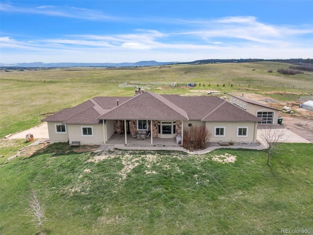 15125 Spring Valley Rd, Larkspur, CO 80118 - rear view of property with stucco siding, a patio area, a yard, and a rural view