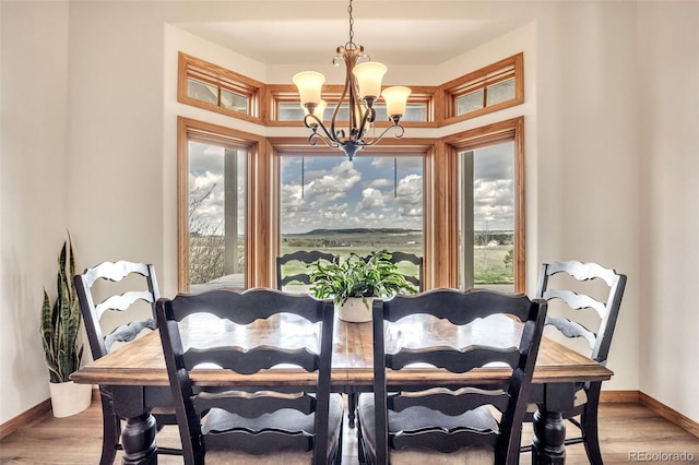 15125 Spring Valley Rd, Larkspur, CO 80118 - dining area featuring a chandelier, baseboards, and light wood-type flooring