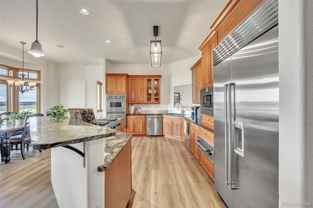 15125 Spring Valley Rd, Larkspur, CO 80118 - kitchen featuring built in appliances, a sink, light wood-style flooring, recessed lighting, and brown cabinets
