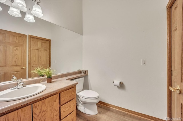 15125 Spring Valley Rd, Larkspur, CO 80118 - bathroom with toilet, wood finished floors, baseboards, and vanity