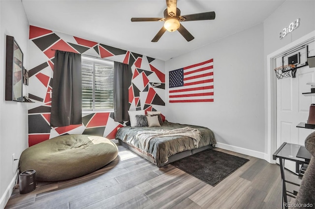 15125 Spring Valley Rd, Larkspur, CO 80118 - bedroom with wood finished floors, baseboards, ceiling fan, and an accent wall
