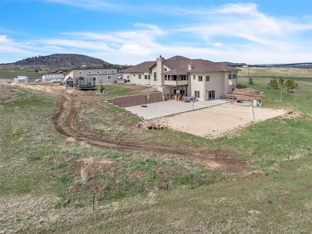 15125 Spring Valley Rd, Larkspur, CO 80118 - back of house with a patio, a mountain view, and stucco siding