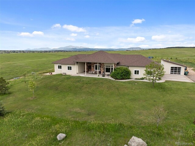 15125 Spring Valley Rd, Larkspur, CO 80118 - rear view of house featuring a patio area, a lawn, a mountain view, and stucco siding