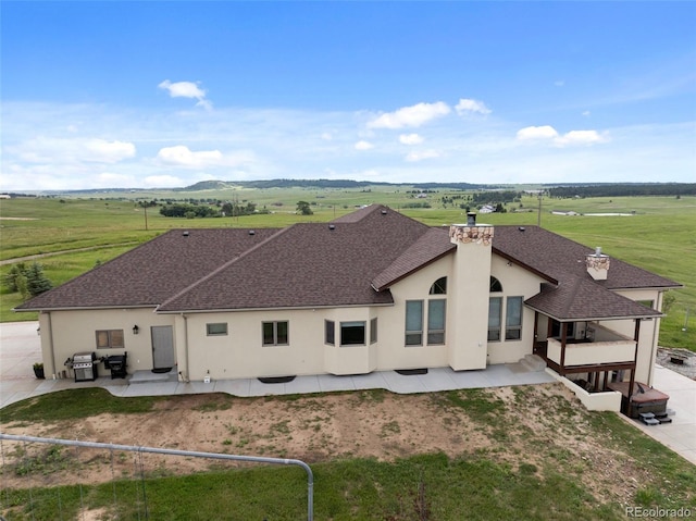 15125 Spring Valley Rd, Larkspur, CO 80118 - rear view of property with stucco siding, a patio, a shingled roof, and a chimney