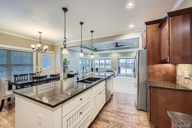 kitchen with sink, decorative light fixtures, a center island with sink, appliances with stainless steel finishes, and white cabinets