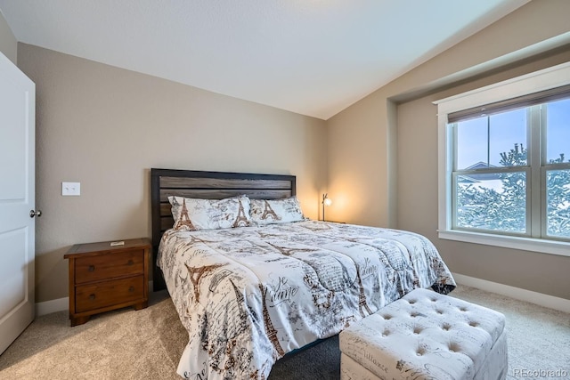 bedroom with lofted ceiling and light colored carpet