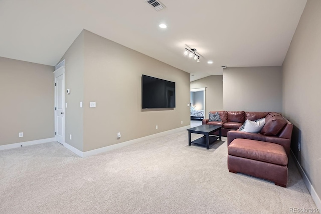 living room featuring rail lighting, lofted ceiling, and light carpet