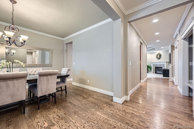 dining space featuring a notable chandelier, crown molding, and wood-type flooring