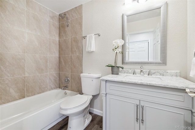 full bathroom featuring toilet, vanity, hardwood / wood-style floors, and tiled shower / bath