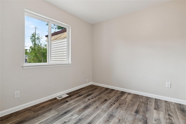 unfurnished room with a healthy amount of sunlight and wood-type flooring