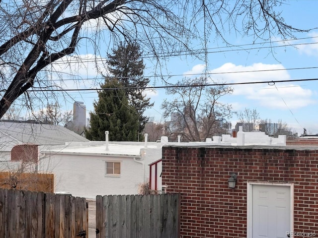 view of property exterior featuring brick siding and fence