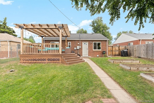 rear view of house featuring brick siding, a vegetable garden, a lawn, a deck, and a fenced backyard