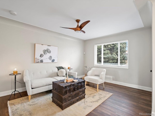 living area with ceiling fan, wood finished floors, visible vents, and baseboards