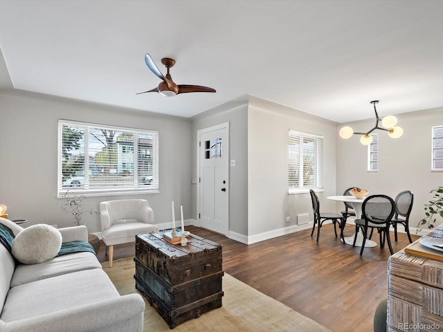 living area featuring a wealth of natural light, dark wood-style flooring, and baseboards