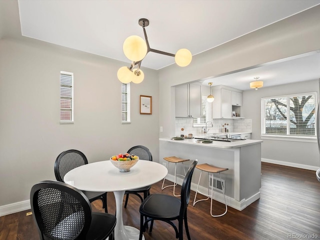 dining space with visible vents, baseboards, and dark wood finished floors