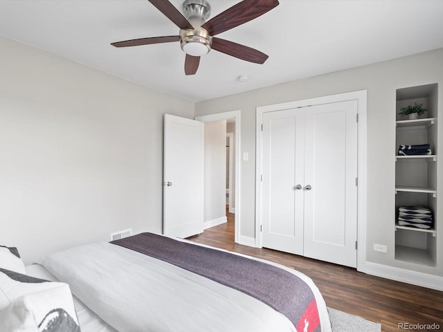 bedroom featuring ceiling fan, wood finished floors, visible vents, and baseboards