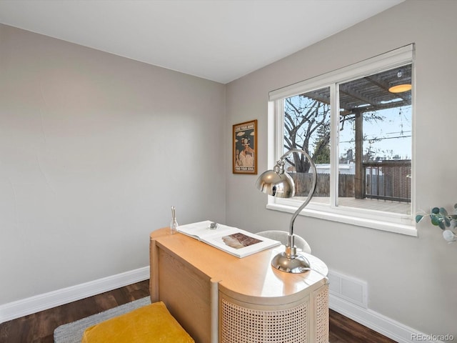 office area featuring dark wood-type flooring, visible vents, and baseboards