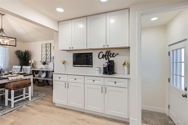 8985 Lander St, Westminster, CO 80031 - kitchen with black microwave, white cabinetry, light countertops, a chandelier, and recessed lighting