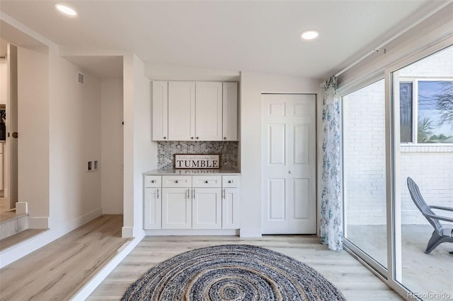 8985 Lander St, Westminster, CO 80031 - kitchen featuring light wood-style flooring, white cabinets, decorative backsplash, baseboards, and recessed lighting