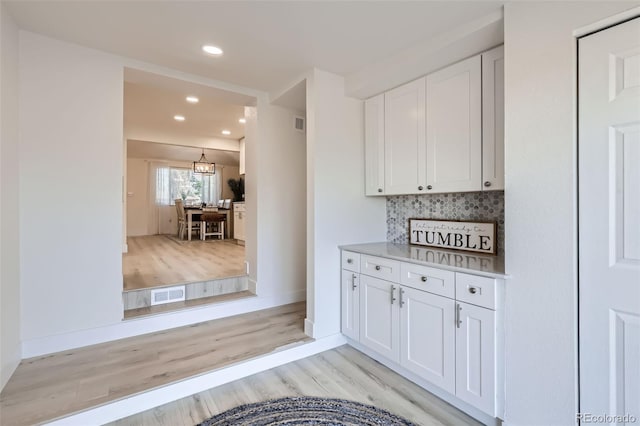 8985 Lander St, Westminster, CO 80031 - kitchen featuring light wood-type flooring, recessed lighting, white cabinets, backsplash, and baseboards