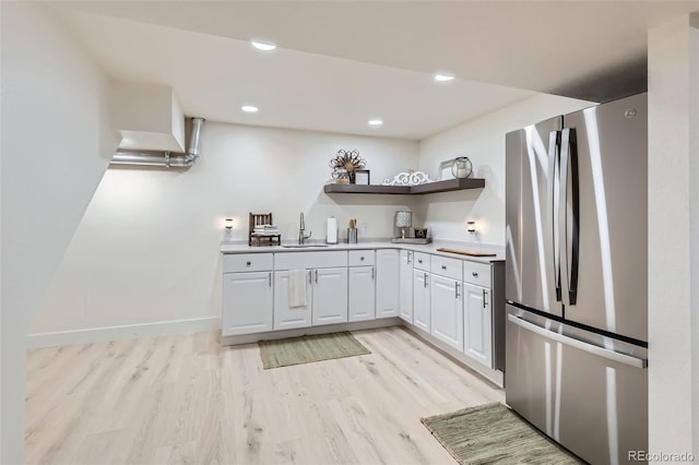 8985 Lander St, Westminster, CO 80031 - kitchen featuring freestanding refrigerator, open shelves, a sink, light wood-style flooring, and white cabinetry